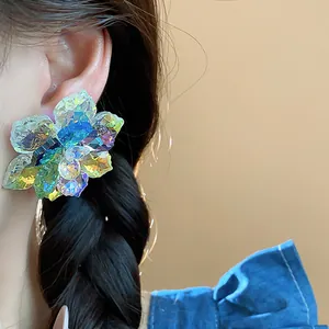Gros plan d'une boucle d'oreille en cristal irisé en forme de fleur sur un mannequin