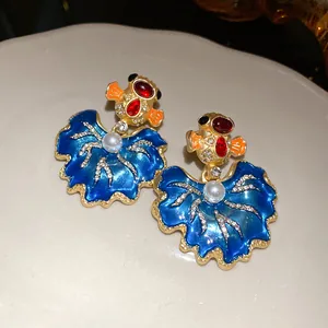Vintage gold fish enamel earrings with blue leaf design and sparkling crystals detail