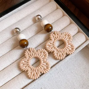 Detailed macro view of resin flower earrings with wooden and white beads.
