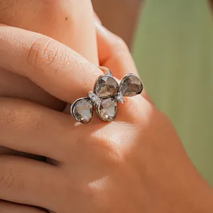 Gros plan d'une bague papillon de luxe avec pierres gris fumé et strass brillants