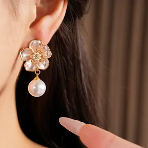 Vue détaillée de boucles d'oreilles fleurs élégantes avec perles et aiguille en argent.