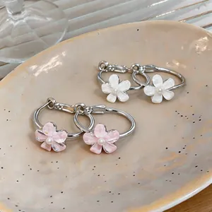 Detailed view of sweet resin flower hoop earrings in white and pink with pearl centers