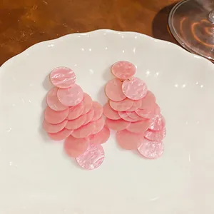 Vista dettagliata di orecchini a perno in acrilico rosa marmorizzato con dischi