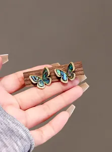 Close-up of vintage butterfly earrings with colorful abalone shell inlay and micro-paved zirconia.