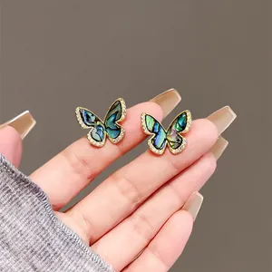 Macro detail of vintage shell butterfly stud earrings with micro-pave cubic zirconia
