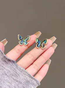 Detailed view of vintage shell butterfly earrings with sparkling micro-set zircons