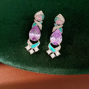 Close-up of palace style earrings with purple pear-shaped zircon and teal enamel detail