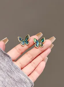 Detailed view of vintage abalone shell butterfly stud earrings with micro-set CZ