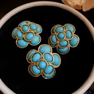Close-up detail of vintage turquoise blue resin flower earrings with gold-tone plating