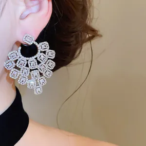 Macro detail view of luxury geometric silver-tone earrings with sparkling clear zircons