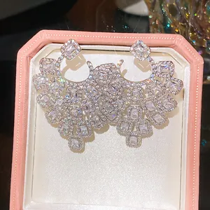 Detailed close-up view of luxury sparkling silver zircon openwork earrings in a pink velvet box