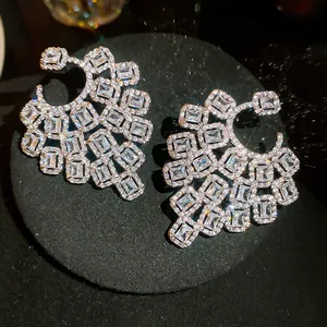Detailed close-up of luxurious geometric hollow earrings with sparkling crystals.