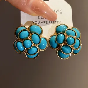 Detail view of vintage palace style flower earrings with turquoise resin beads