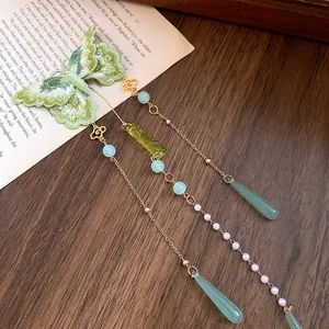 Vue détaillée de la pince à cheveux papillon brodée verte avec des glands de perles élégants
