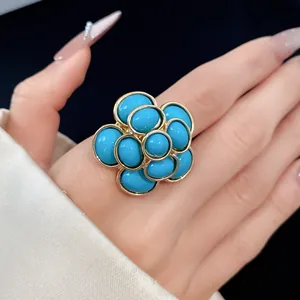 Detailed close-up view of a vintage gold-toned flower ring with blue resin cabochons