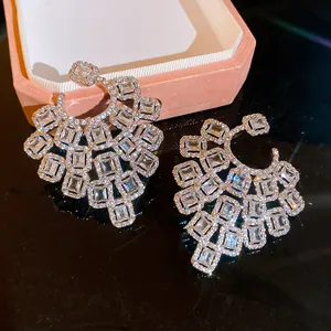 Close-up of luxury chandelier earrings with sparkling emerald-cut cubic zirconia