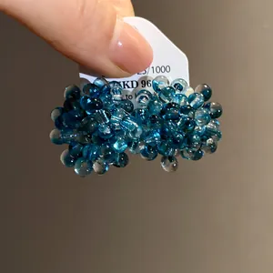 Detail showing the intricate deep blue bead cluster design of floral stud earrings.