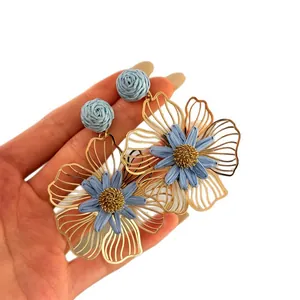 Orecchini a fiore in paglia intrecciata stile resort in blu e oro per le vacanze.