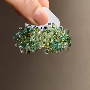 Detailed macro shot of elegant green and blue glass bead cluster floral stud earrings