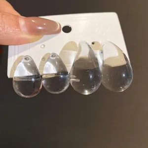 Elegant minimalist transparent acrylic teardrop stud earrings shown on a display card