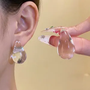 Minimalist clear acrylic water drop stud earrings with steel needles shown on model