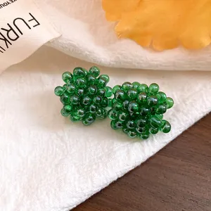 Macro detail of exquisite green beaded flower stud earrings with silver needles