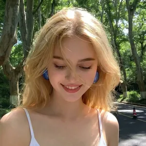 Macro view of vibrant blue bubble-like retro stud earrings on a blonde model in sunlight.