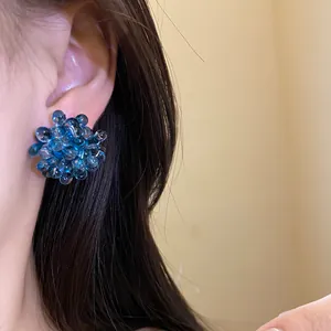 Close-up of deep sea blue floral beaded earring worn on earlobe for an elegant style