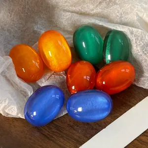 Detail of colorful resin oval earring stones with cat-eye shimmer effect.