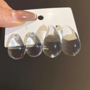 Close-up of clear acrylic teardrop earrings showing transparent design and size.