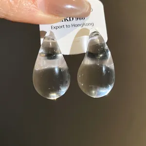 Close-up of transparent acrylic water drop stud earrings with minimalist design
