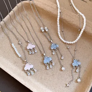 Detail view of cloud necklaces with zircon water drops and pearls on a natural tray