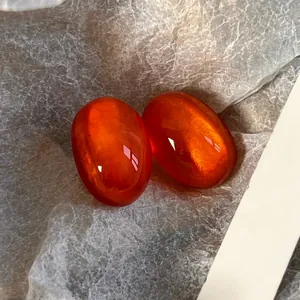 Macro detail of French vintage orange jelly resin earrings with bubble effect