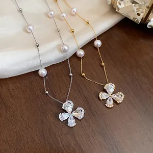 Close-up of 18k gold plated zirconia flower and pearl necklaces in gold and silver tones