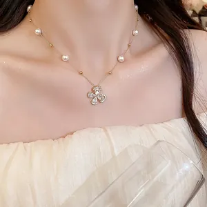 Close-up of a delicate 18k gold-plated flower necklace with white pearls and zircons
