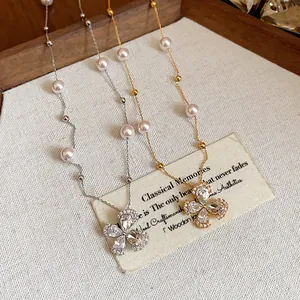 Detailed view of elegant 18k gold plated zircon flower pearl necklaces on textured background