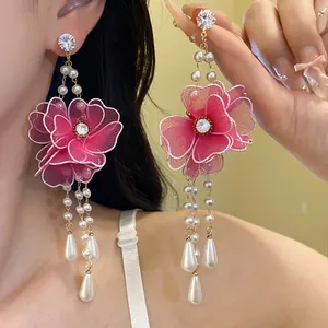 Detailed view of large pink mesh flower earrings featuring elegant pearl tassels for women