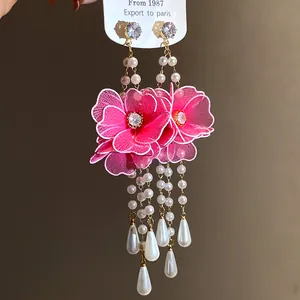 Detailed view of pink mesh flower earrings with pearl teardrop tassels