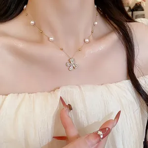 Detailed view of 18k gold plated zircon flower necklace with pearls on a female model