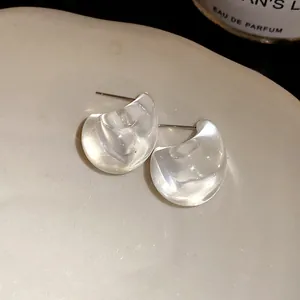 Close-up macro view of clear acrylic water drop stud earrings with minimalist design.