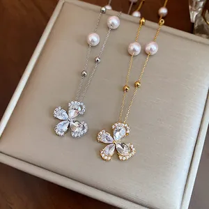 Detail shot of silver and gold plated zircon flower pearl necklaces on jewelry pad