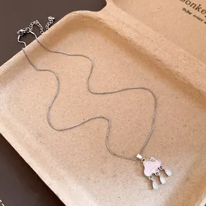 Detailed macro view of a silver cloud pendant necklace with pink enamel and sparkling tassels
