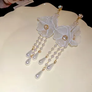 Macro view showing the delicate mesh flower and dangling pearl tassel drop earrings.
