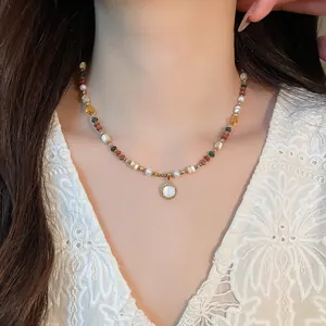 Close-up of 18K gold plated beaded necklace with pearls and stones on a model's neck