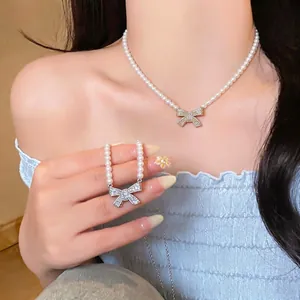 Elegant 18k gold plated pearl necklace featuring a sparkling rhinestone bow pendant