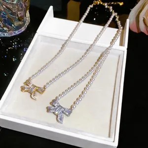 Elegant 18k gold plated pearl necklace featuring a sparkling cubic zirconia bow pendant.