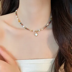 Close-up of bohemian beaded stone necklace with 18K gold plated pearl pendant
