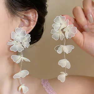 Close-up detail of elegantly designed handmade white mesh floral long tassel earrings.