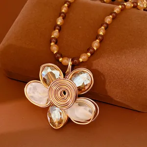 Détail du collier pendentif fleur fait main avec perles en verre et fil métallique