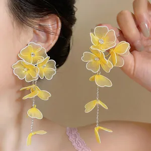 Detailed close-up of handmade yellow fabric flower drop earrings with sparkling crystals